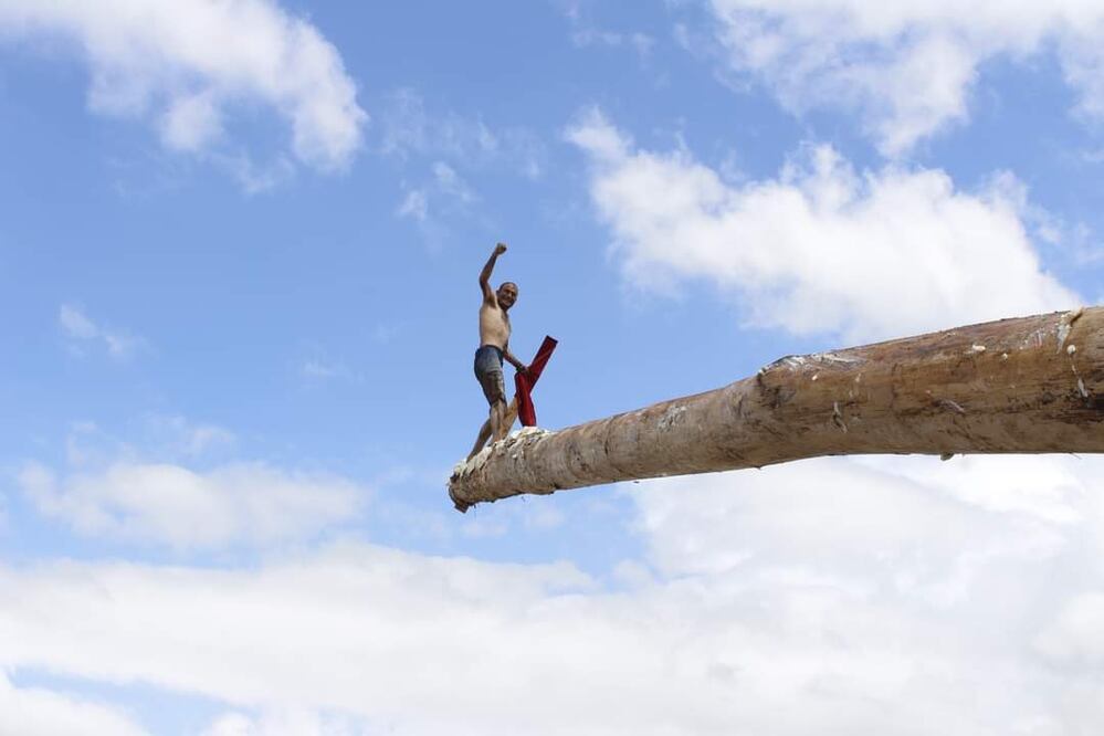 Carlos Moreno Amador gana por segundo año consecutivo en la tradicional Cucaña, se lleva un guajolote, una bicicleta y seis mil pesos en efectivo. I foto: Grisel Lira