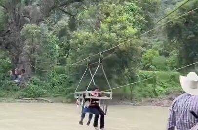 Niños cruzan río en teleférico improvisado para ir a la escuela en Jacala