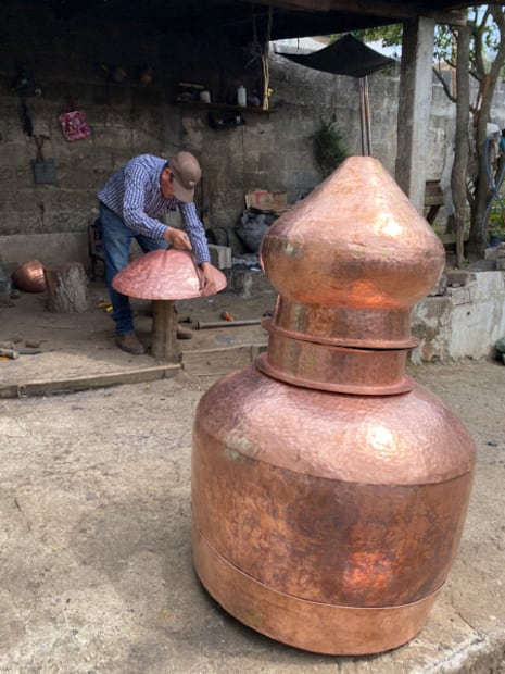 Luciano Guzmán Gutiérrez pone sus manos ya curtidas sobre el vientre redondo de un alambique recién creado. Dice que “cada uno tiene su propio carácter”, como si hablara de una persona. I Foto: Luis Soriano