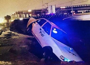 Taxi cae en un socavón tras inundaciones en Pachuca