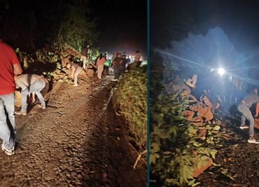 Pasajeros despejan derrumbe en la carretera Huejutla-Pachuca para continuar su viaje